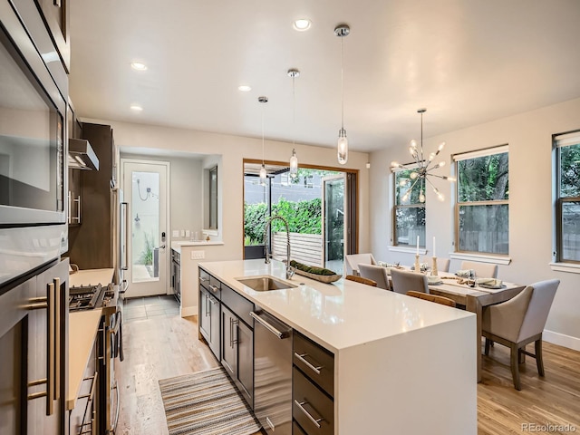 4535 Stuart St, Denver, CO 80212 - kitchen with appliances with stainless steel finishes, healthy amount of natural light, light wood-type flooring, a kitchen island with sink, and recessed lighting