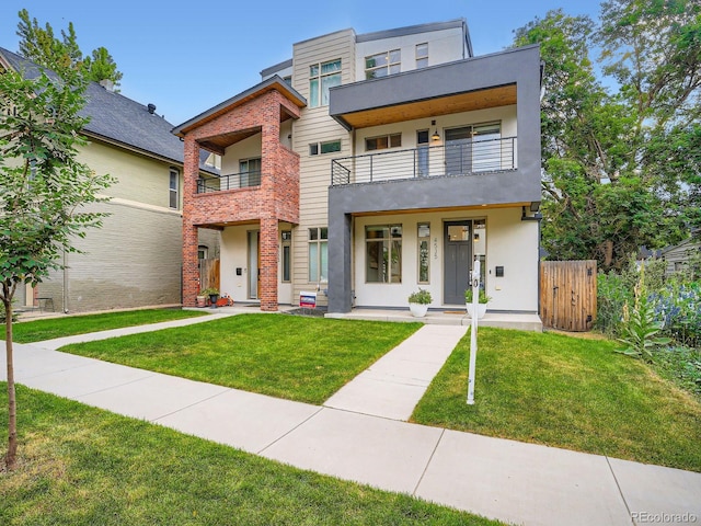 4535 Stuart St, Denver, CO 80212 - view of front of house with a front yard, a balcony, and stucco siding