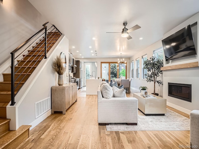 4535 Stuart St, Denver, CO 80212 - living room featuring stairway, ceiling fan, light wood-style flooring, a chandelier, and recessed lighting