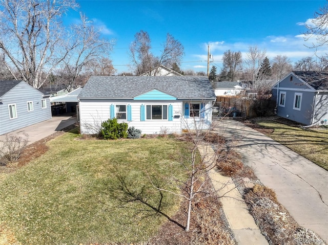 view of front facade featuring a carport, concrete driveway, a front yard, and roof with shingles