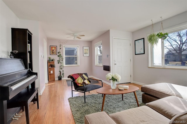 living area with light wood-style flooring, a healthy amount of sunlight, and baseboards