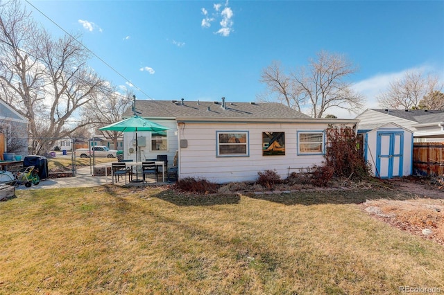 back of house featuring a patio, a gate, fence, a storage unit, and a lawn