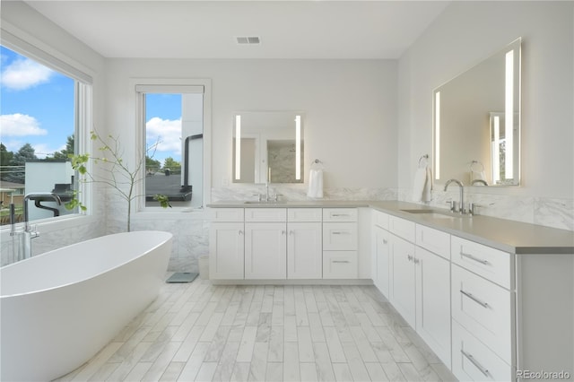 3450 S Cherry St, Denver, CO 80222 - full bathroom featuring double vanity, a freestanding bath, and tile walls