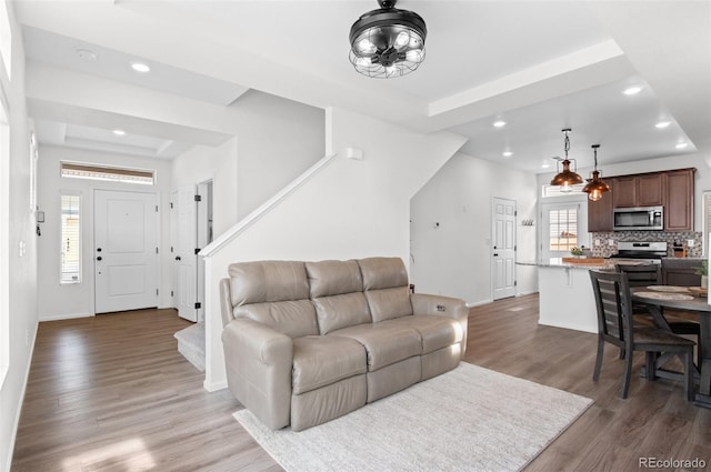 living room with baseboards, stairway, wood finished floors, and recessed lighting