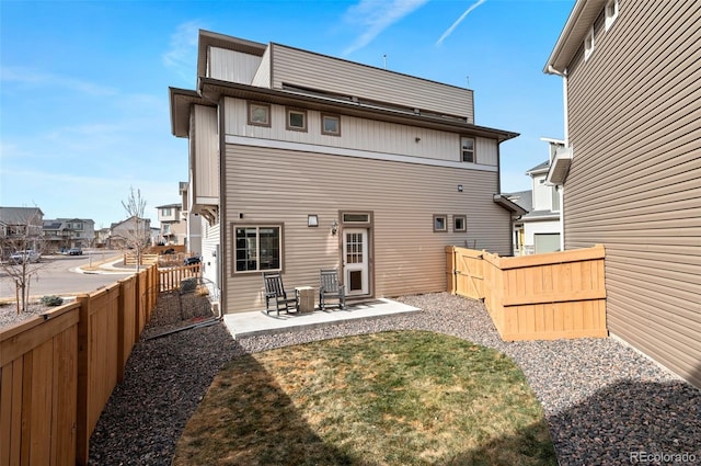 back of property with a fenced backyard and a patio