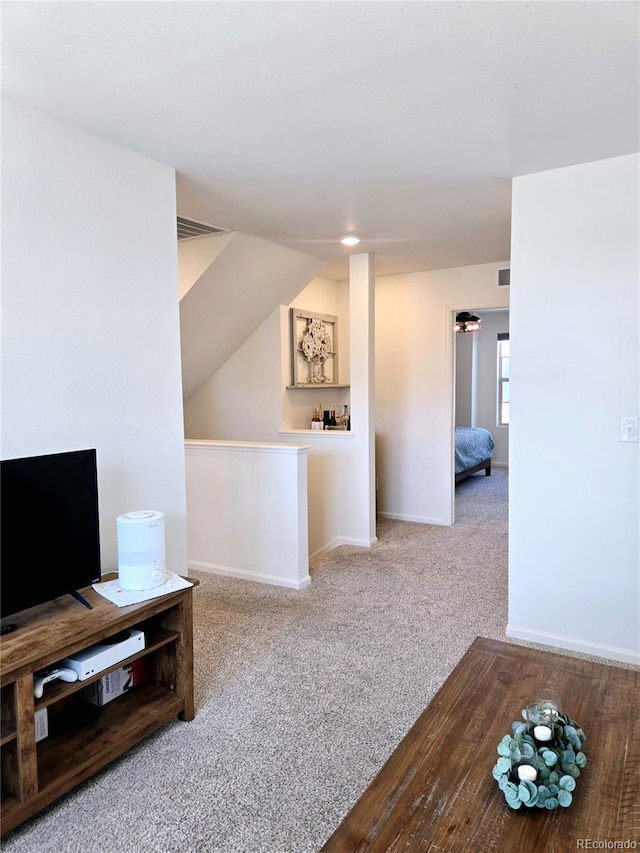 living room featuring carpet floors, visible vents, baseboards, and vaulted ceiling