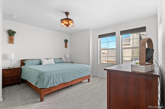 bedroom featuring light colored carpet and baseboards