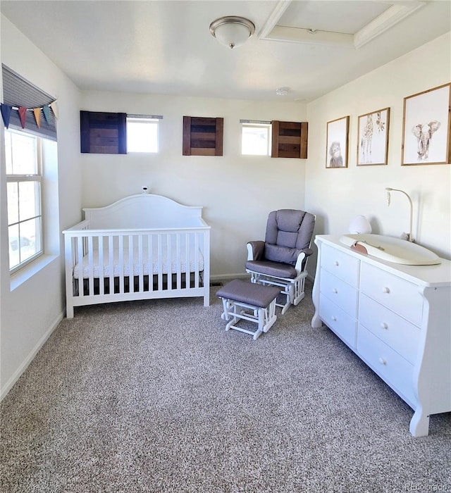 bedroom featuring a crib, baseboards, and carpet flooring