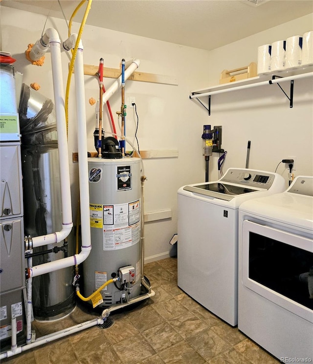 washroom featuring laundry area, water heater, and washer and clothes dryer