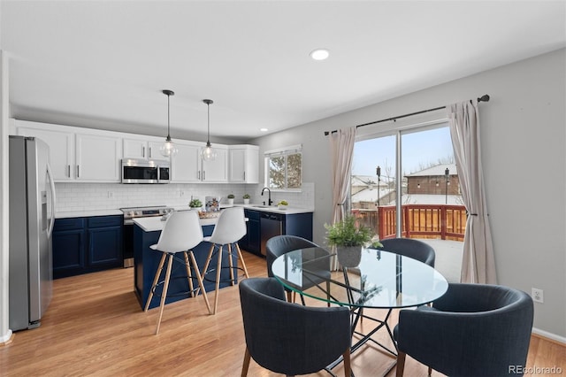 dining space featuring light wood-type flooring and recessed lighting