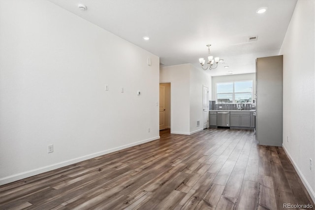 unfurnished living room with dark hardwood / wood-style floors and a notable chandelier