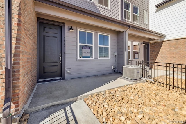 entrance to property with cooling unit and brick siding