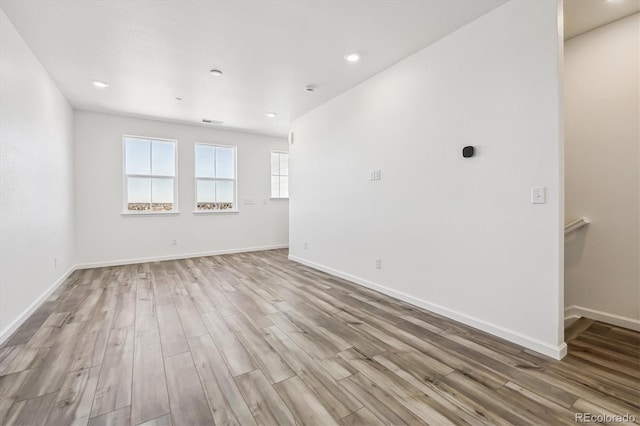 unfurnished room with recessed lighting, visible vents, baseboards, and wood finished floors