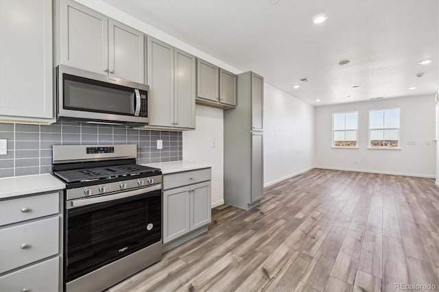 kitchen featuring stainless steel appliances, light countertops, and gray cabinetry