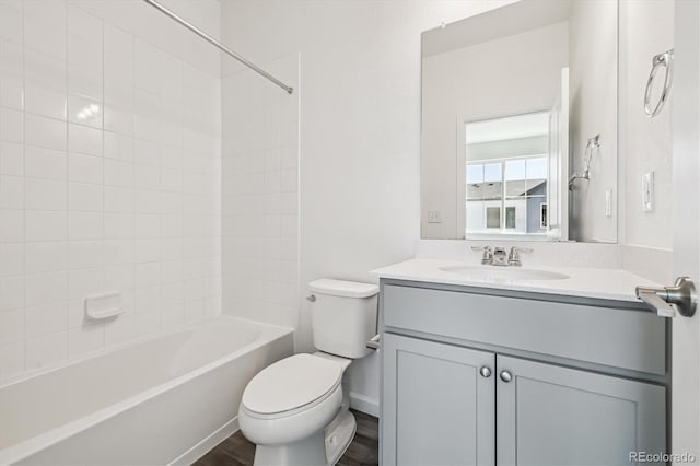 bathroom with toilet, shower / bathtub combination, wood finished floors, and vanity