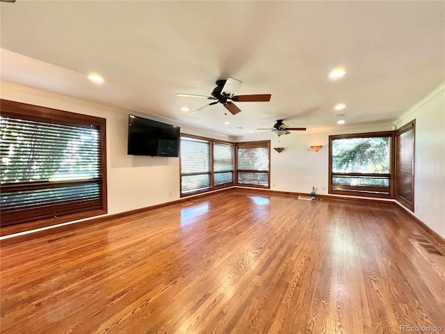 unfurnished living room featuring crown molding, baseboards, plenty of natural light, and a ceiling fan