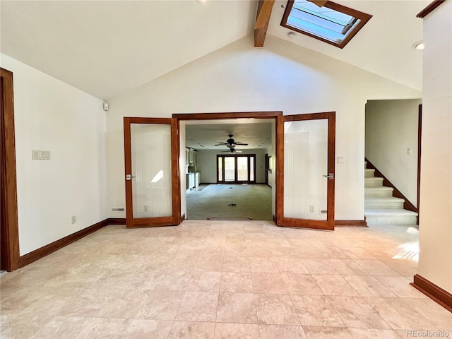 spare room with a skylight, baseboards, and french doors