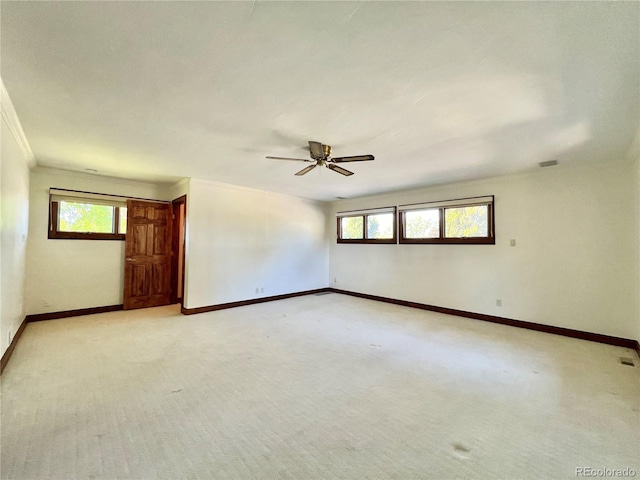 empty room with a ceiling fan, baseboards, ornamental molding, and a healthy amount of sunlight