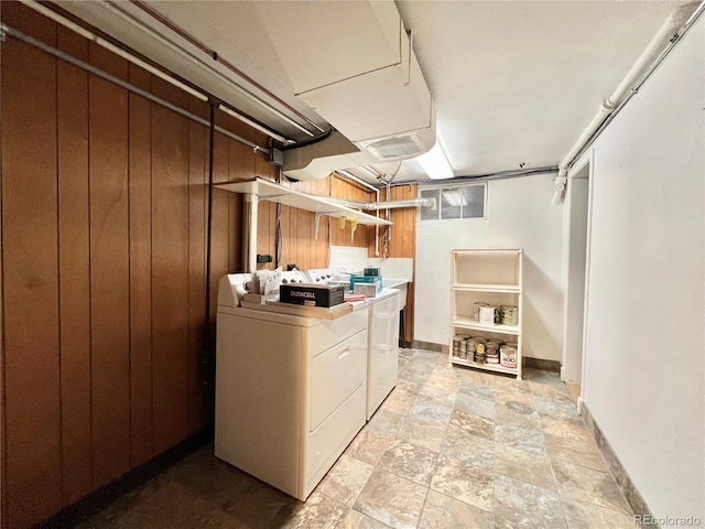 laundry room featuring baseboards, washing machine and dryer, and stone finish floor