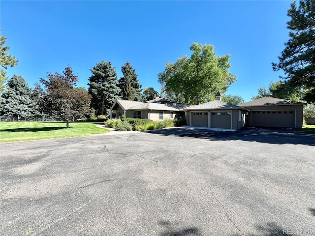 single story home featuring a garage and aphalt driveway