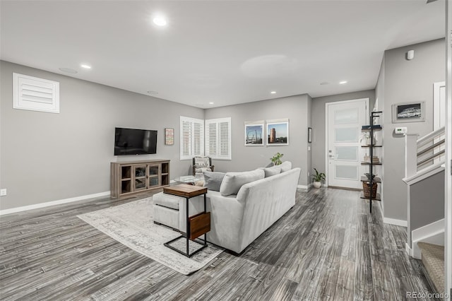 living area with recessed lighting, baseboards, dark wood-style floors, and stairs
