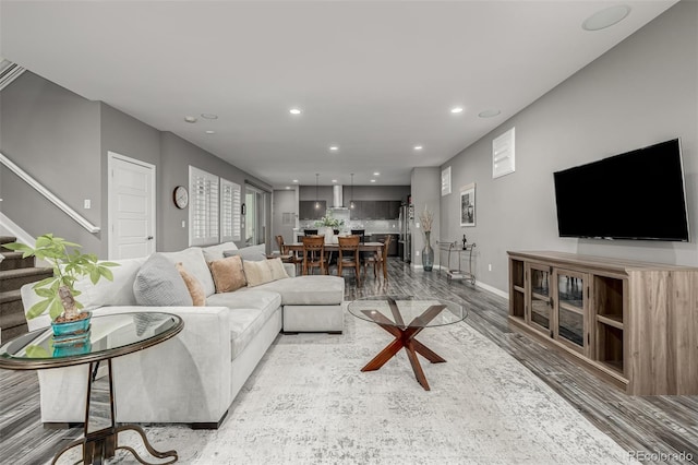 living room with recessed lighting, stairway, baseboards, and wood finished floors