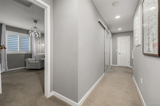 hall with recessed lighting, baseboards, carpet floors, and an inviting chandelier