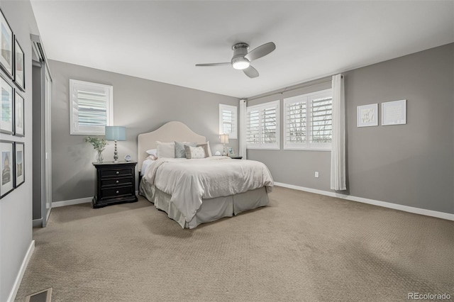 bedroom with ceiling fan, light colored carpet, visible vents, and baseboards