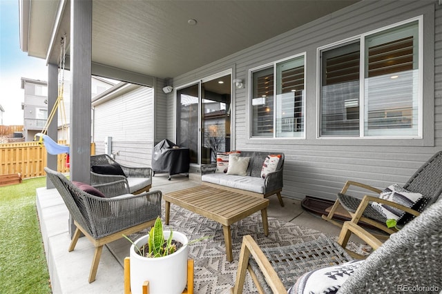 view of patio with grilling area, outdoor lounge area, and fence