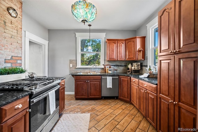 kitchen featuring backsplash, sink, hanging light fixtures, light hardwood / wood-style flooring, and appliances with stainless steel finishes