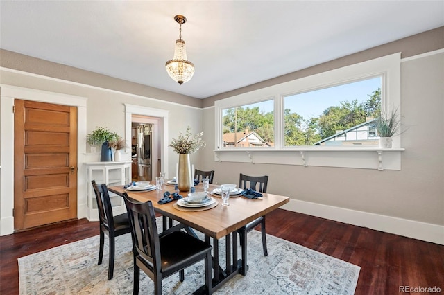 dining space featuring hardwood / wood-style floors and an inviting chandelier