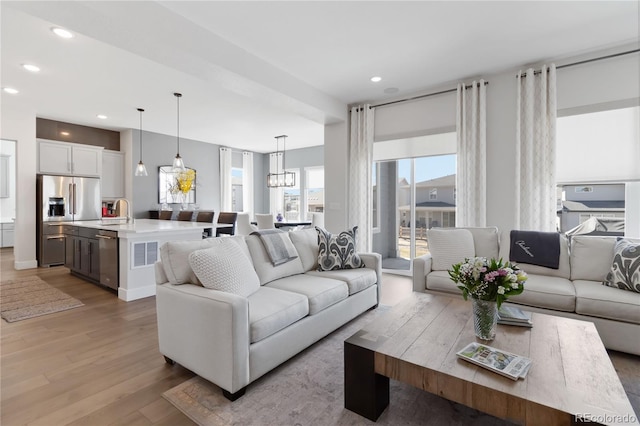 living room with light wood finished floors and recessed lighting