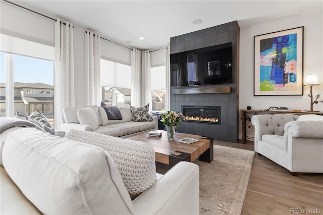 living room with a fireplace, wood finished floors, a wealth of natural light, and recessed lighting