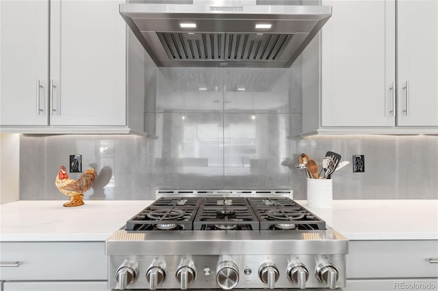 kitchen with light countertops, tasteful backsplash, range with gas stovetop, and custom range hood