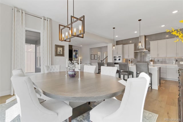 dining area featuring light wood-type flooring, stairway, and recessed lighting
