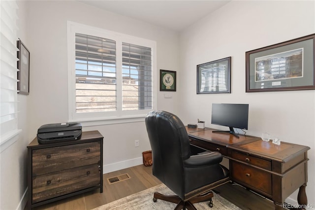 office area with visible vents, baseboards, and wood finished floors