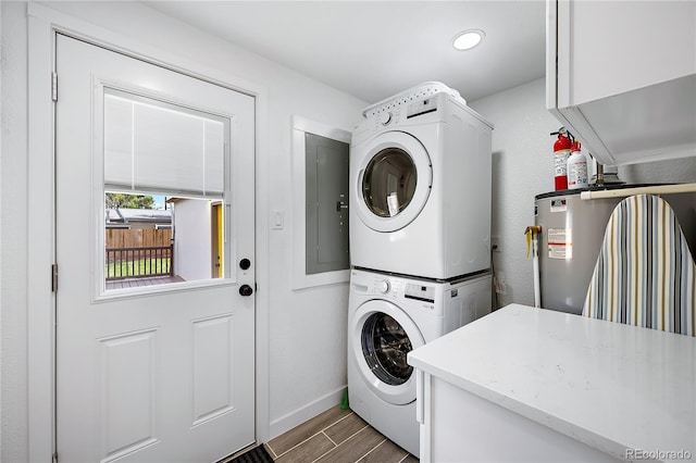 5570 Otis Ct, Arvada, CO 80002 - laundry area featuring stacked washer / dryer, electric panel, wood finished floors, and baseboards