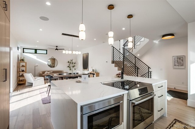 1459 W 42nd Ave, Denver, CO 80211 - kitchen featuring light wood-style flooring, stainless steel appliances, open floor plan, a large island, and modern cabinets