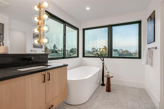 1459 W 42nd Ave, Denver, CO 80211 - bathroom with a freestanding tub, baseboards, vanity, and recessed lighting