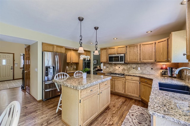 4498 Buena Vista Ct, Castle Rock, CO 80109 - kitchen with appliances with stainless steel finishes, a sink, dark wood-style flooring, a kitchen island, and tasteful backsplash