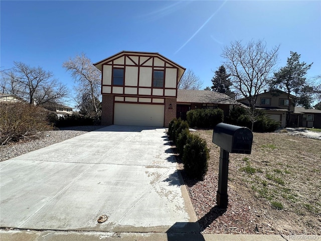 tudor home featuring stucco siding, a garage, and concrete driveway