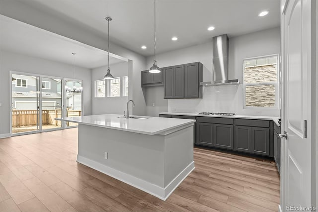 21204 E 63rd Dr, Aurora, CO 80019 - kitchen with a sink, stainless steel gas stovetop, light wood finished floors, light countertops, and wall chimney exhaust hood