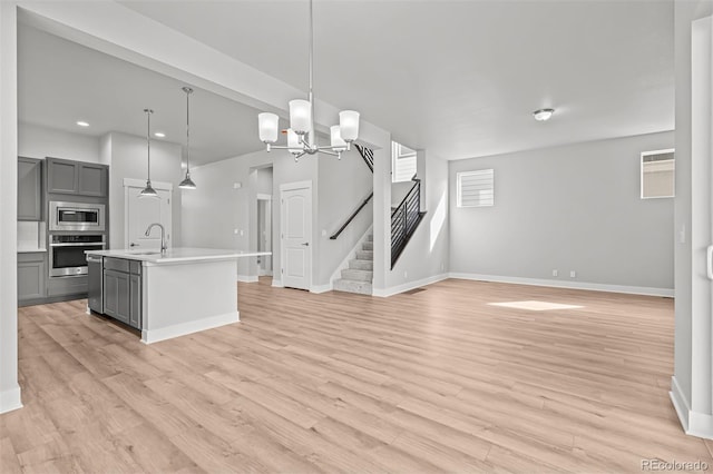 21204 E 63rd Dr, Aurora, CO 80019 - kitchen with an inviting chandelier, light countertops, gray cabinets, baseboards, and appliances with stainless steel finishes