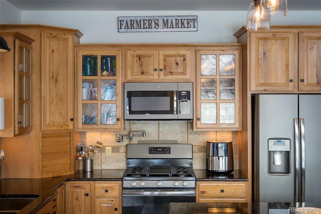 151 County Road 644, Grand Lake, CO 80447 - kitchen with appliances with stainless steel finishes, decorative backsplash, glass insert cabinets, and dark stone countertops