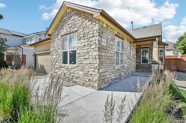 19677 E Vassar Dr, Aurora, CO 80013 - view of home's exterior featuring stone siding, a garage, and concrete driveway