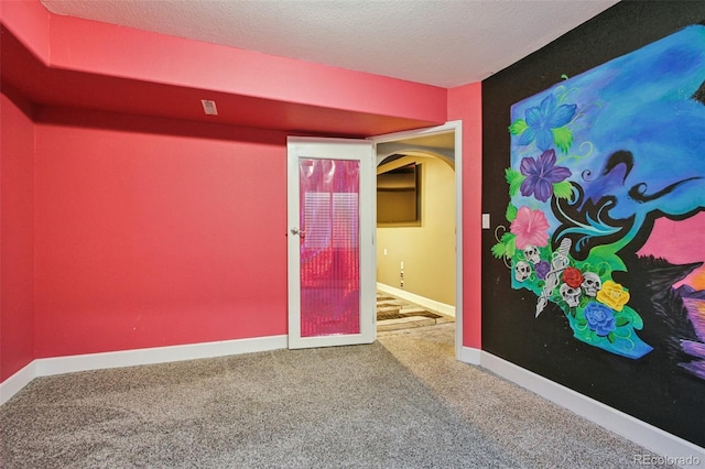 19677 E Vassar Dr, Aurora, CO 80013 - empty room featuring carpet flooring, a textured ceiling, and arched walkways