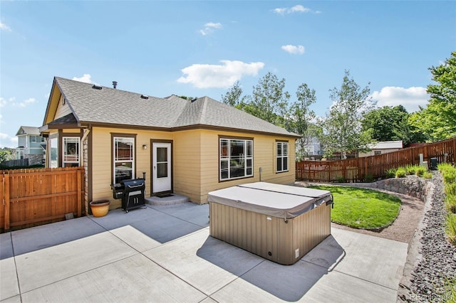 19677 E Vassar Dr, Aurora, CO 80013 - rear view of property with a hot tub, a patio area, a fenced backyard, and a shingled roof