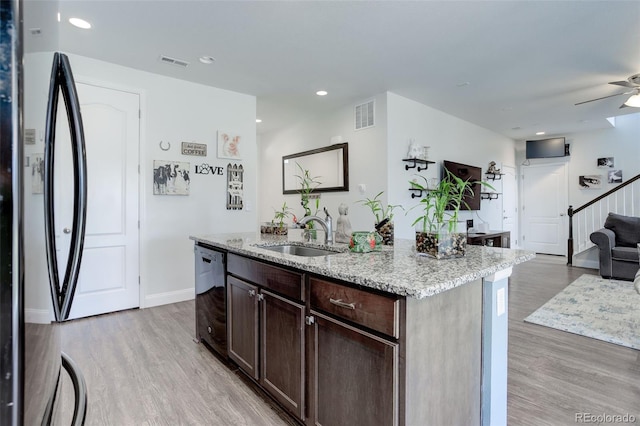 kitchen with dishwasher, sink, a kitchen island with sink, and light hardwood / wood-style flooring