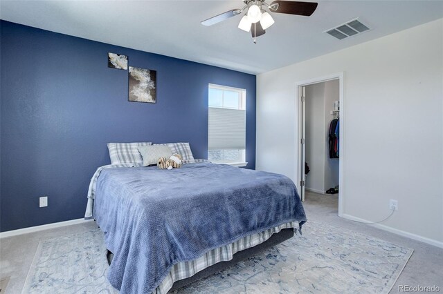 carpeted bedroom with a closet, a spacious closet, and ceiling fan