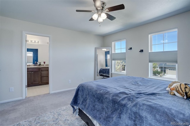 bedroom featuring connected bathroom, light colored carpet, ceiling fan, and sink